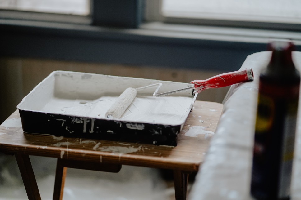 Paint roller in white paint on a table